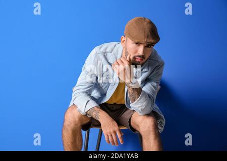 Fashionable young man on color background Stock Photo