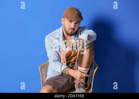 Fashionable young man on color background Stock Photo