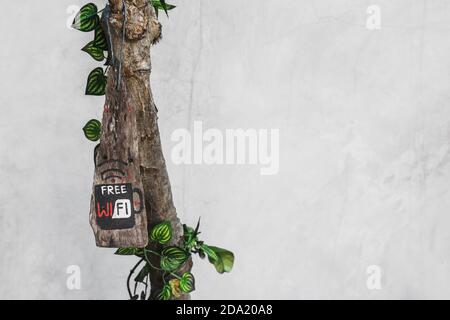 Free wi-fi sign on tree in loft cafe. Gray concrete wall background with empty place and copy space. Trendy interior design Stock Photo