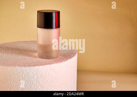 Harvesting perfume bottles without labels on a white podium. Stock Photo