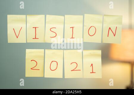 Pasted vision 2021 on wall - Concept for new year 2021 vision or business plan. Stock Photo