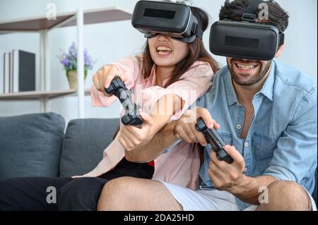 Couple lovers enjoy  playing VR game together at home. Family relationship concept. Stock Photo