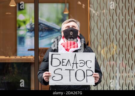 Peaceful protest supporting Belarus against ongoing repressions and call for free with man wearing masks and red and white flags of Belarus Stock Photo