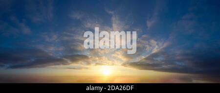 Sunset sky panorama with clouds and orange glow. Stock Photo