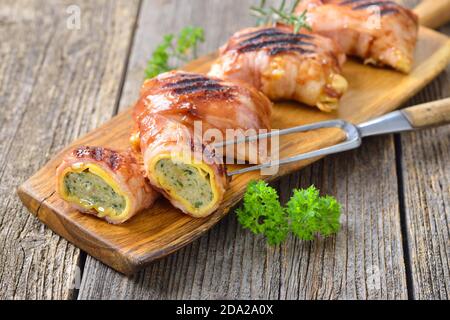 Grilled Swabian meat ravioli, so called Maultaschen, wrapped in cheese and bacon, coated with a spicy barbecue sauce Stock Photo