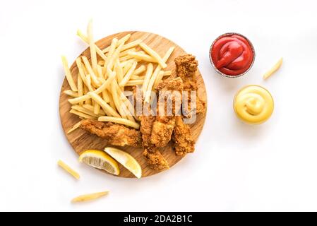 Fish and chips. Deep fried fish filet and with french fries isolated on white background with sauces. Traditional british street food, top view, copy Stock Photo