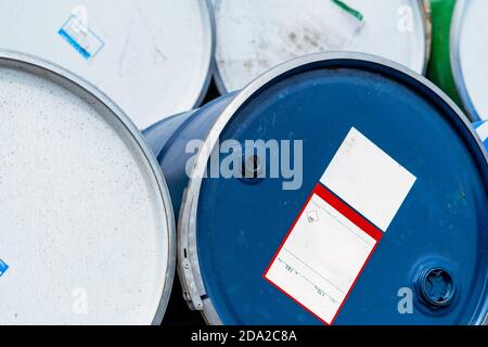 Selective focus on old chemical barrels. Blue oil drum. Steel oil tank. Toxic waste warehouse. Hazard chemical barrel with warning label. Industrial. Stock Photo