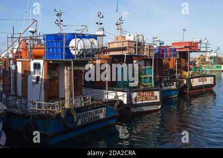 fishing boats or vessels in a line or row in Kalk Bay harbour, Cape Town, South Africa concept commercial fishing industry in Africa Stock Photo