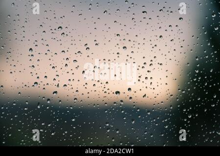 Water drops on window glass after rain. Macro of raindrops as abstract background with shallow depth of field. Rainy weather, melancholic mood. Stock Photo