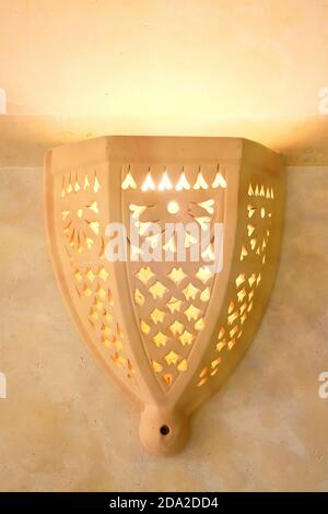 Yellow lamp in Arab style. Wall clay lamp in an arabic house in the middle East. Patterns on the wall lantern. Stock Photo
