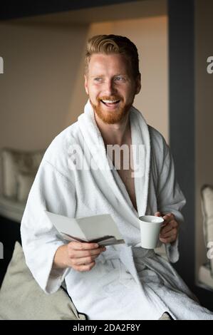Young man drinking coffee in the morning at hotel, spa Stock Photo