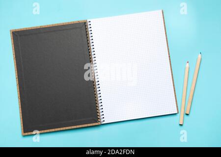 Flat lay opened blank squared notebook withred and blue color pencils high angle view with copy space Stock Photo