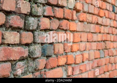 Red brick wall in receding perspective. Geometric composition of rectangular clay bricks. Multitasking background. Without anyone. Stock Photo