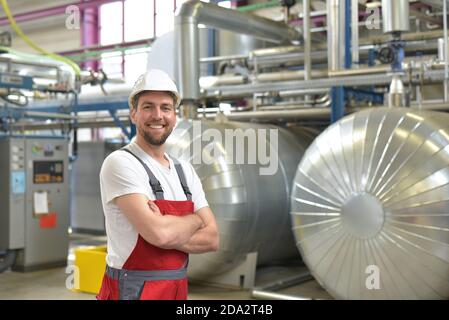 portrait of successful smiling workers/ engineers on site in an industrial factory with helmet Stock Photo