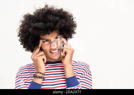 Close up portrait young man with headache pushing fingers against temple Stock Photo