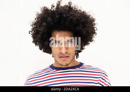 Close up portrait serious young arabic man with afro hair against isolated white background Stock Photo