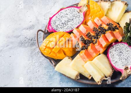 Assortment Set of Cutting Tropical Fruits. Papaya Pine Apple Mango Sapodilla Dragon on the tray Stock Photo