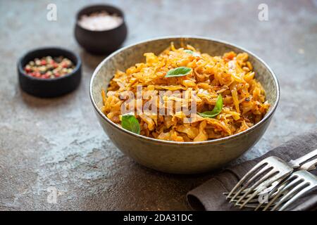 Stewed or braised cabbage served in a bowl on dark stone background, close up Stock Photo