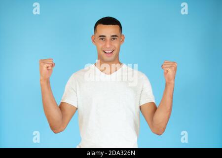 Lucky young man wearing casual clothes over blue background Stock Photo