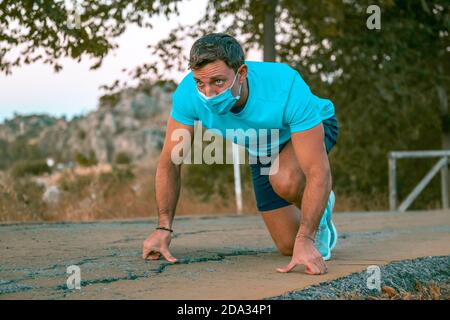 Portrait of a young caucasian man wearing a blue t-shirt preparing to go for a run in a park Stock Photo