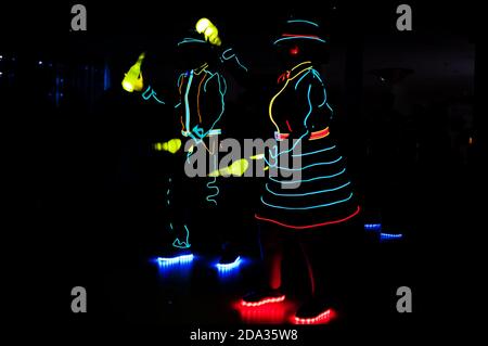 Professional barman and led light show. Silhouette of modern bartender shaking drink at night cocktail bar. Stock Photo