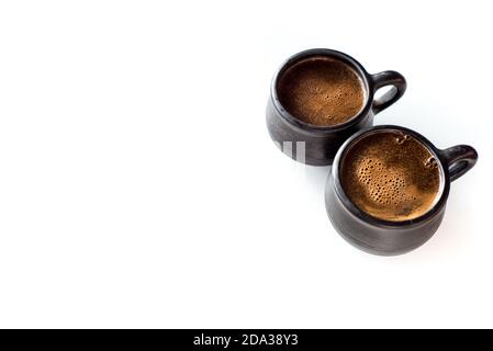 Two black earthenware ceramic coffee cups isolated on a white table. Morning aromatic hot coffee Stock Photo