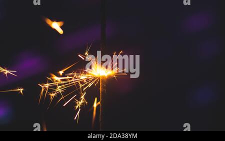 Photos on a bright blue purple background with sparklers festive lights holiday and Christmas and New Year on the desktop or banner on the website Stock Photo