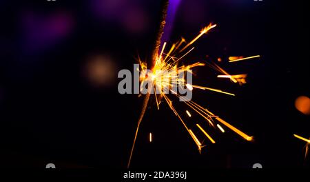 Photos on a bright blue purple background with sparklers festive lights holiday and Christmas and New Year on the desktop or banner on the website Stock Photo