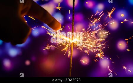 Photos on a bright blue purple background with sparklers festive lights holiday and Christmas and New Year on the desktop or banner on the website Stock Photo