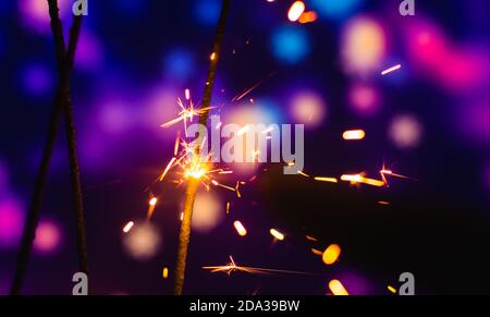 Photos on a bright blue purple background with sparklers festive lights holiday and Christmas and New Year on the desktop or banner on the website Stock Photo