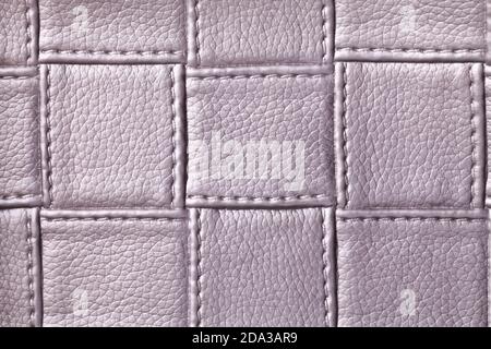 Texture of purple leather background with square pattern and stitch, macro. Abstract backdrop from modern decorative light violet textile with geometr Stock Photo