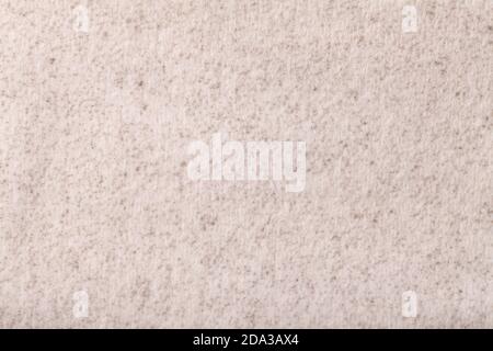 Light beige fluffy background of soft, fleecy cloth. Texture of cream color wool textile backdrop, closeup. Stock Photo