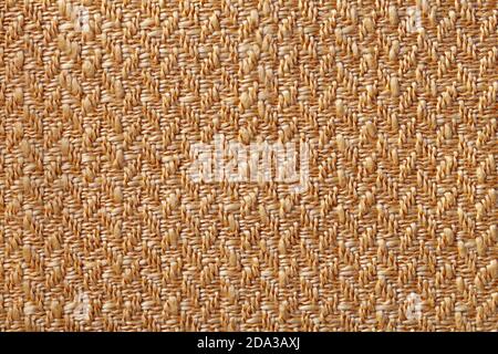 Dark orange wicker textile background, closeup. Structure of the light brown woven fabric backdrop, macro. Stock Photo
