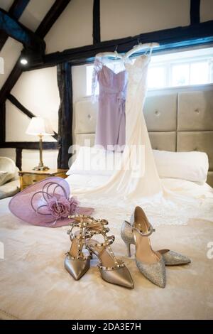 Party shoes and formal hat on a bed in a hotel bedroom. Stock Photo