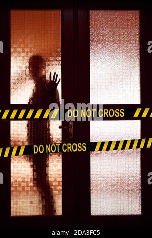 Barrier tape quarantine, isolation. Not cross. Woman behind the matte glass door blurred silhouette Stock Photo