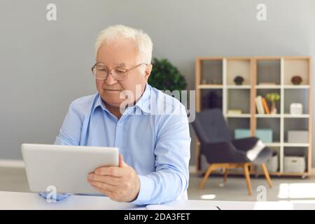 Senior man using tablet to book medical appointment, check pension plan or read news Stock Photo