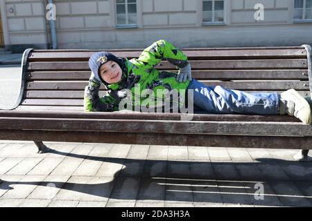 Child lying on bench in Moscow city Stock Photo