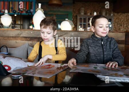 Two brothers with menu books in restaurant Stock Photo