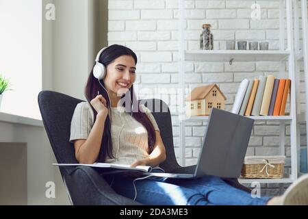 Young woman student attend online class, webinar or internet lecture from home using laptop computer Stock Photo