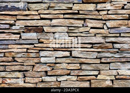 Sandstone stone wall mosaic, expressive texture and background. Stock Photo