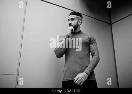 Portrait of stylish arab beard man wear grey turtleneck. Arabian model guy against steel wall. Stock Photo