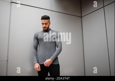 Portrait of stylish arab beard man wear grey turtleneck. Arabian model guy against steel wall. Stock Photo