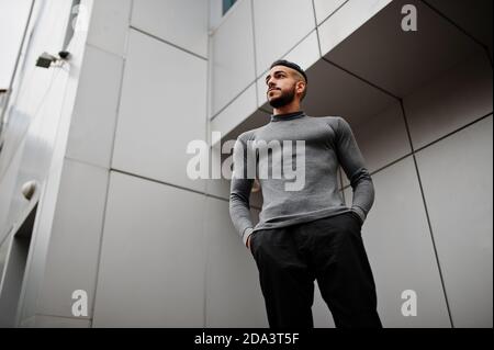 Portrait of stylish arab beard man wear grey turtleneck. Arabian model guy against steel wall. Stock Photo