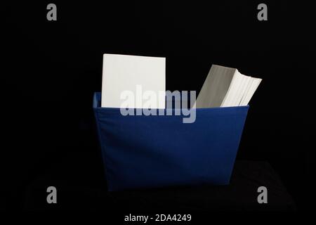 Blue ballot carrier with blank white envelopes on a black background. Some envelopes facing forward some facing sideways. Carrier is blue cloth with b Stock Photo