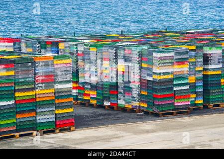 Colorful boxes plastic crates. Packing containers piles for fish storage of catch. Stock Photo