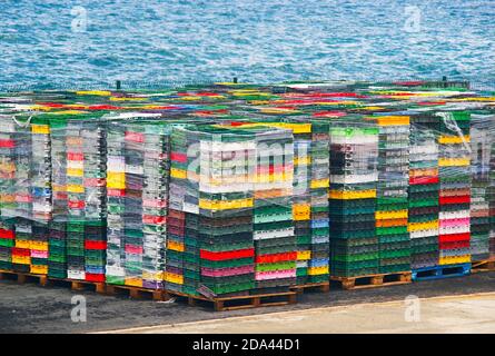 Colorful boxes plastic crates. Packing containers piles for fish storage of catch. Stock Photo
