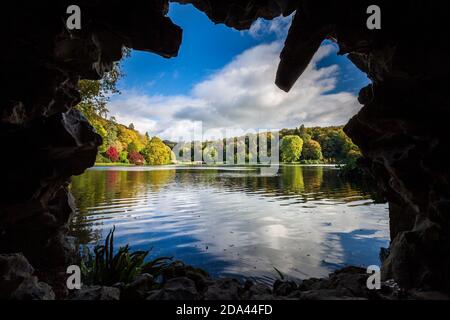 Autumn colour across the lake from the Grotto at Stourhead in Wiltshire, England Stock Photo