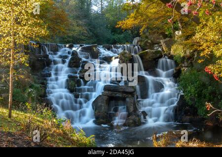 The ornamental cascade or waterfall at Virginia Water Lake in Windsor Great Park during autumn, England, UK Stock Photo