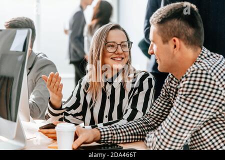 colleagues discussing something sitting at a table in the office Stock Photo