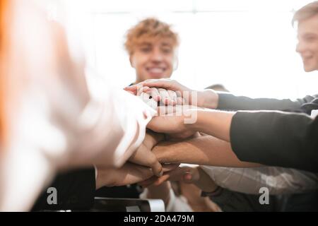 group of diverse young people joining their palms together Stock Photo